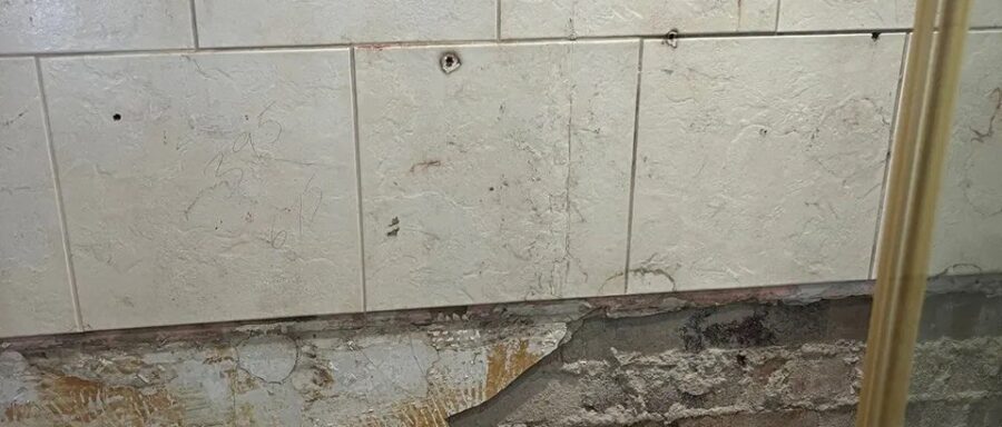 Exposed masonry after removing the damaged shower wall finish