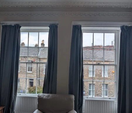 Dark curtains installed around two tall sash windows in a Gateshead sitting room