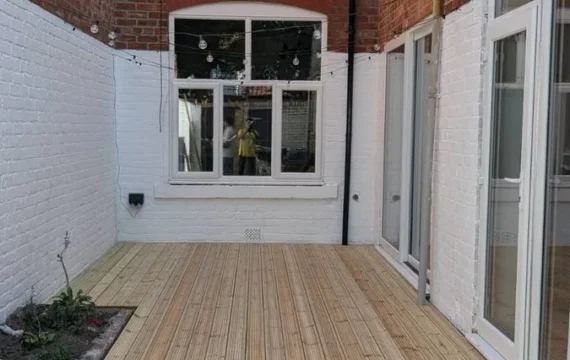 Finished courtyard decking beside freshly painted white walls