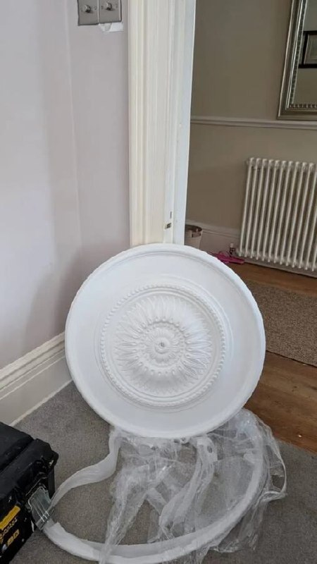Decorative ceiling rose before installation around an existing chandelier in Newcastle