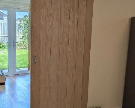 Completed oak sliding door fitted on a black track