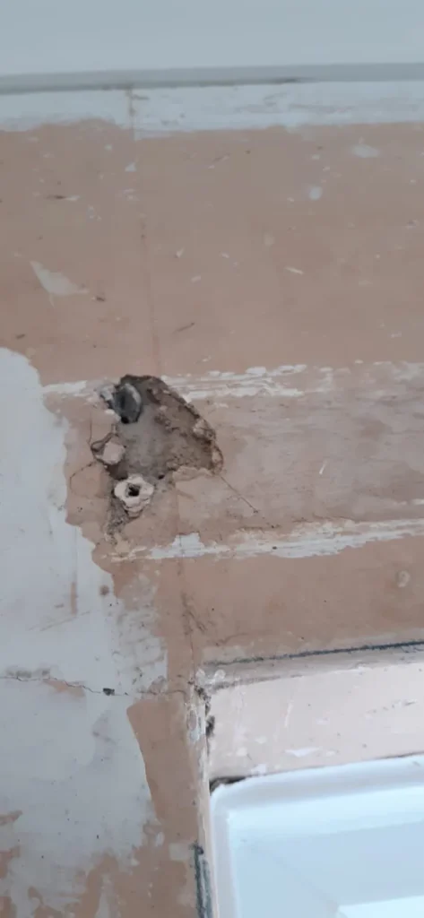 Damaged plaster and a hole above an internal doorway