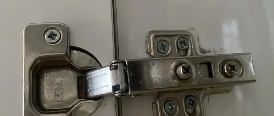 Replacement concealed hinge fitted to a white kitchen cupboard door after repair by Handyman MultiFix.